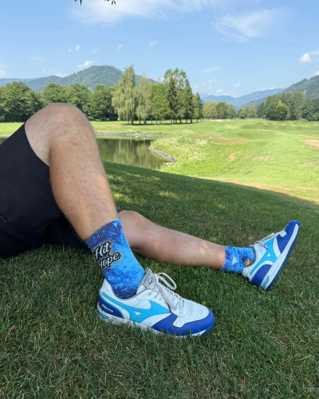 Frau sitzt auf Küstenfelsen und trägt HIT AND HOPE Socken